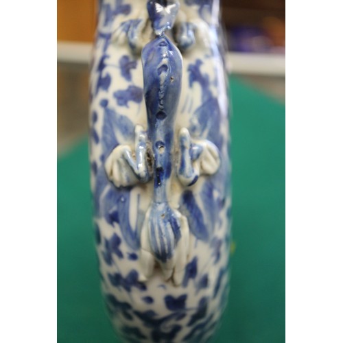 105 - A Chinese blue and white moon flask with relief lizard, leaf and scrolled decoration, 9 1/2