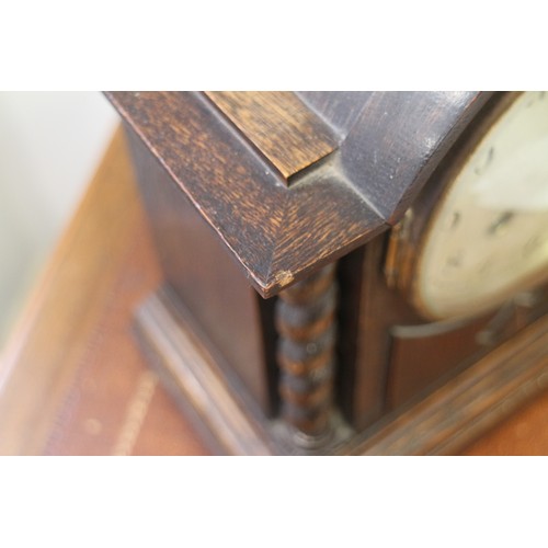 137 - An oak cased arch top mantel clock with barley twist columns, silvered dial and Arabic numerals, 12 ... 