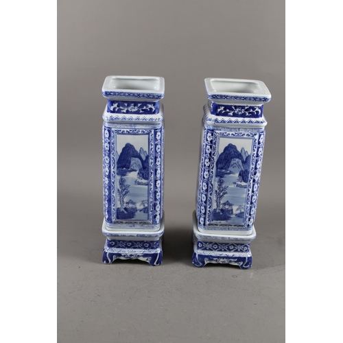 122 - A pair of Chinese blue and white square landscape decorated jars with seal marks to base, on stands,... 