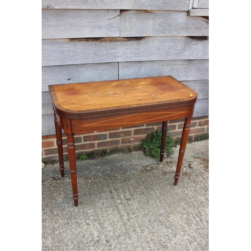 541 - An early 19th century mahogany rosewood banded and box line inlaid fold-over top card table, on turn... 