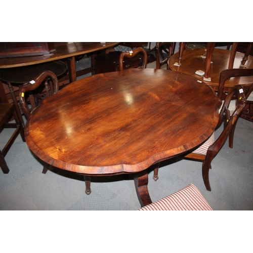 556 - A 19th century Continental rosewood serpentine shape tilt top loo table, on triform column and splay... 