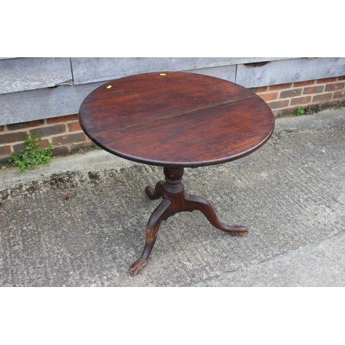 566 - A Georgian mahogany circular tilt top occasional table, on turned column and tripod splayed supports... 