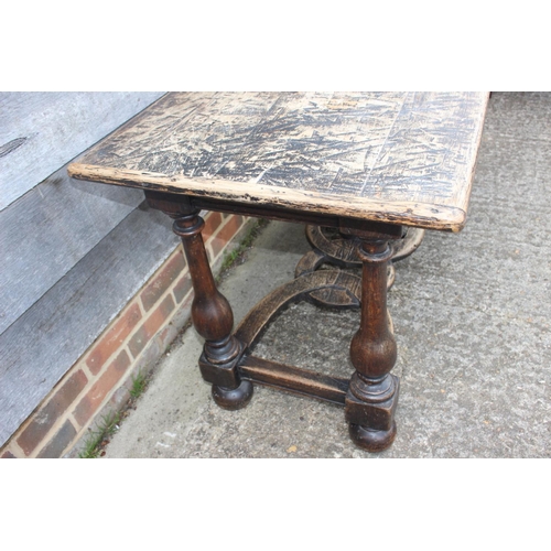 552 - An oak carved table of early 17th century design, on vase turned columns and united by a pierced str... 