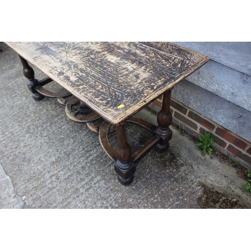 552 - An oak carved table of early 17th century design, on vase turned columns and united by a pierced str... 