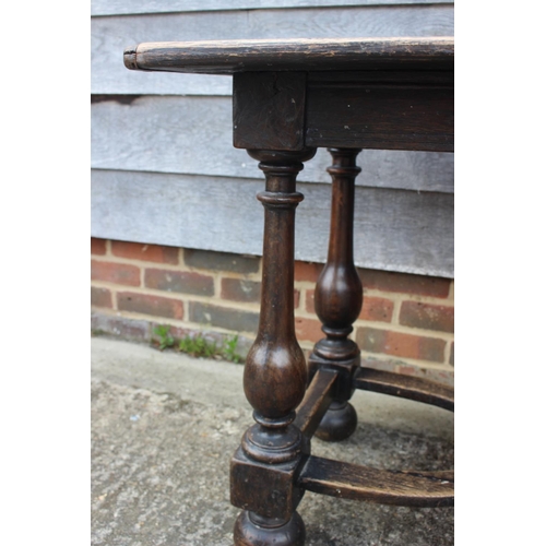 552 - An oak carved table of early 17th century design, on vase turned columns and united by a pierced str... 