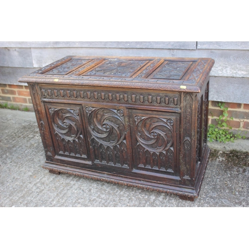 553 - A chip carved oak coffer of 16th century design with three Gothic panel front, on stile supports, 39... 