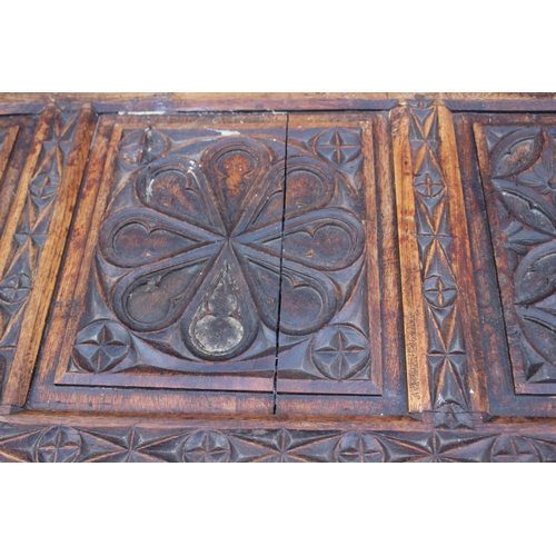 553 - A chip carved oak coffer of 16th century design with three Gothic panel front, on stile supports, 39... 