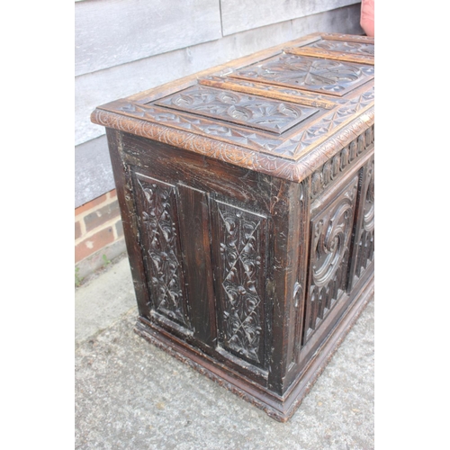 553 - A chip carved oak coffer of 16th century design with three Gothic panel front, on stile supports, 39... 