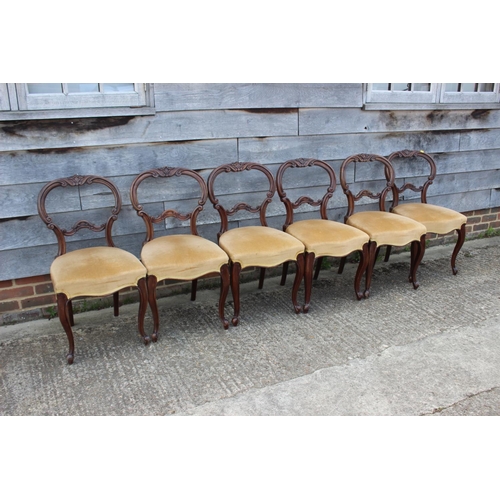 575 - A set of six mid Victorian carved walnut balloon back dining chairs with stuffed over seats, on cabr... 