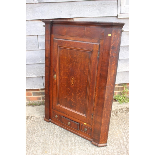 582 - A late Georgian quarter cut oak and mahogany banded corner hanging cupboard enclosed  panel door, 36... 