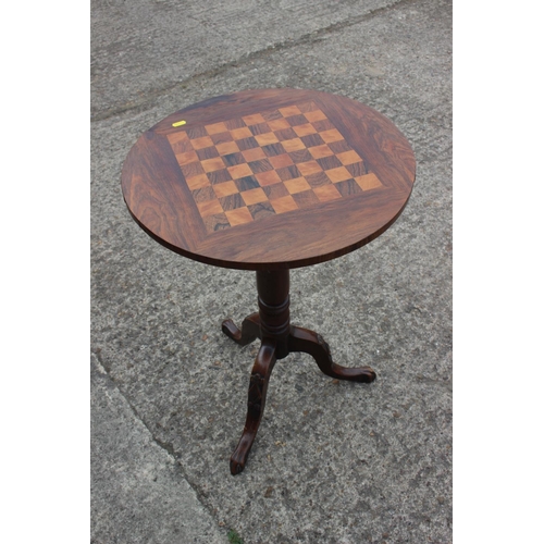 586 - A 19th century rosewood and satinwood games table, on turned column and carved tripod splay supports... 