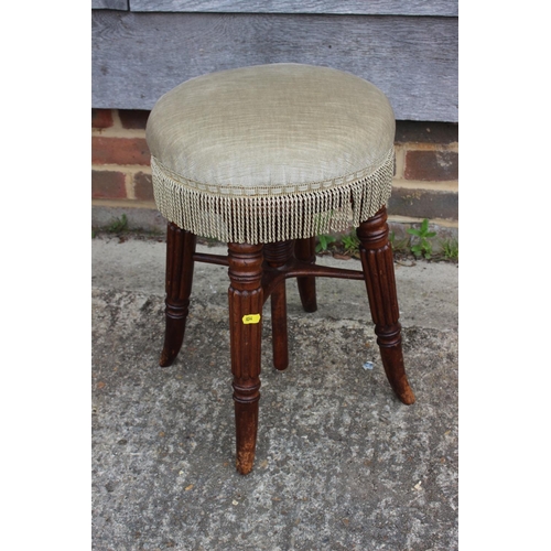 593 - A mid 19th century mahogany piano stool with circular adjustable seat, on reeded stretchered support... 