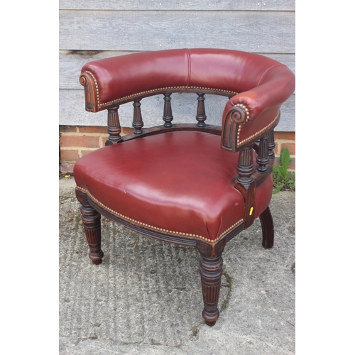 597 - A 19th mahogany tub shape desk elbow chair, upholstered in a red leather, on reeded supports