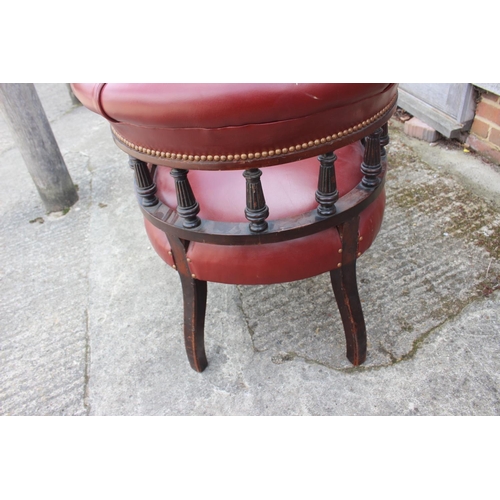 597 - A 19th mahogany tub shape desk elbow chair, upholstered in a red leather, on reeded supports