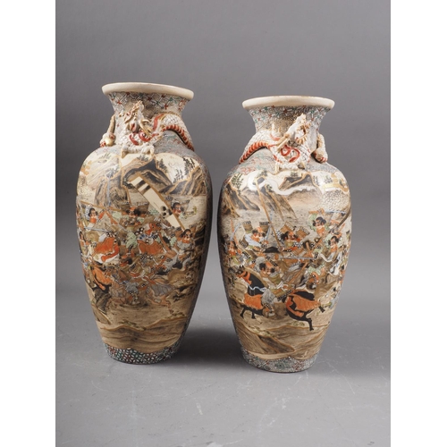 100 - A pair of Japanese Satsuma vases with panelled battle and figures in a landscape decoration and reli... 