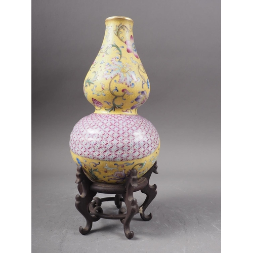 103 - A Chinese double gourd vase with flower, fruit and geometric decoration on a yellow ground, 7 1/2