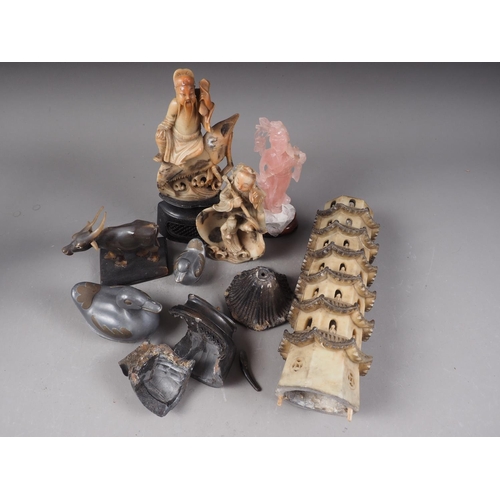 112 - A Chinese pink hardstone figure of a deity, on hardwood stand, 6 1/2