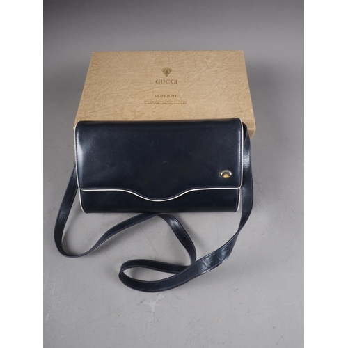 220 - A 1980s Gucci navy blue leather clutch/shoulder bag with detachable strap, in original box and dust ... 