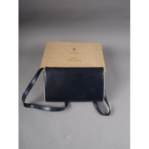 220 - A 1980s Gucci navy blue leather clutch/shoulder bag with detachable strap, in original box and dust ... 