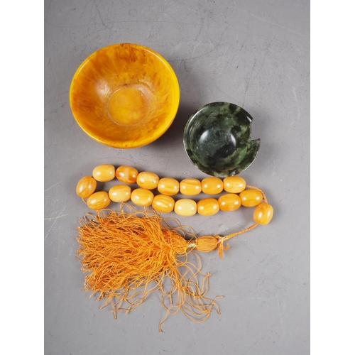 248 - An amber composition bowl, a set of similar prayer beads and a jade bowl (damages)