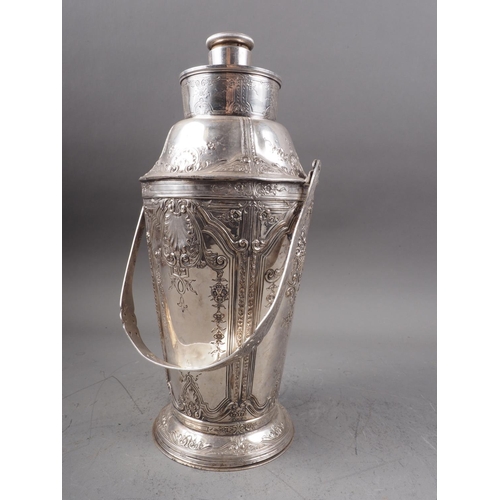 278 - A silver plated cocktail shaker with embossed decoration and swing handle, 12