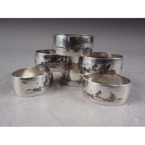 286 - A set of six Eastern white metal napkin rings with niello enamel landscape decoration, 3.8oz troy ap... 