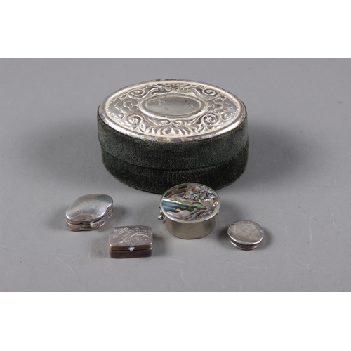 303 - A white metal shaped pill box, stamped 925, another similar with engraved decoration, another with a... 