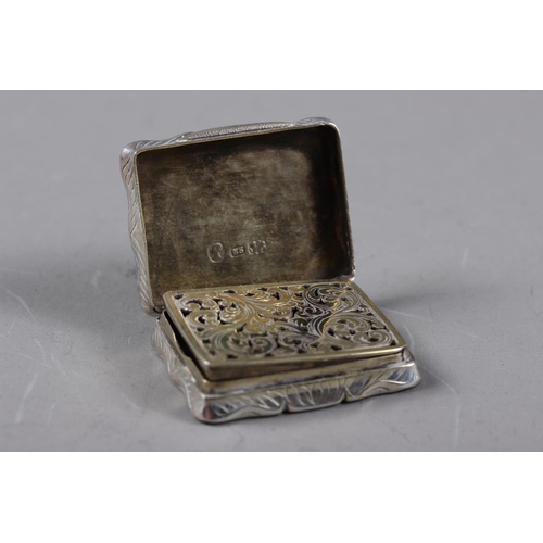 304 - A Victorian silver vinaigrette with silver gilt interior and engraved scrolled decoration, 1 1/2