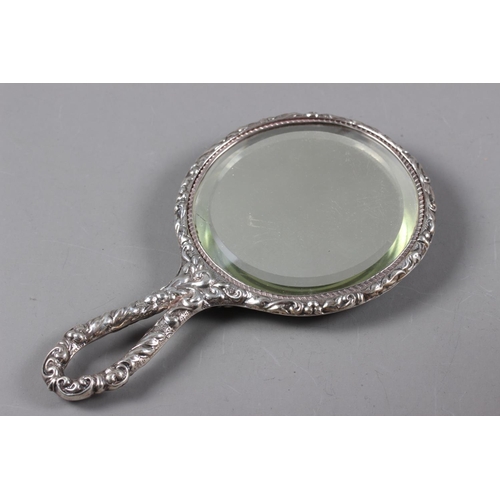 317 - A silver backed dressing table mirror with embossed decoration (damages), two silver topped dressing... 