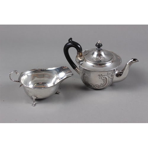 321 - A silver teapot with embossed decoration and ebonised handle and knop, and a silver sauce boat, 9.3o... 