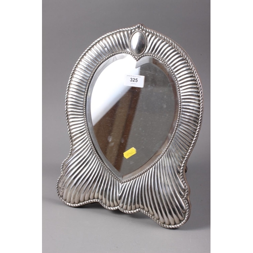 325 - A silver framed shaped dressing table easel mirror with fluted design and heart-shaped bevelled plat... 