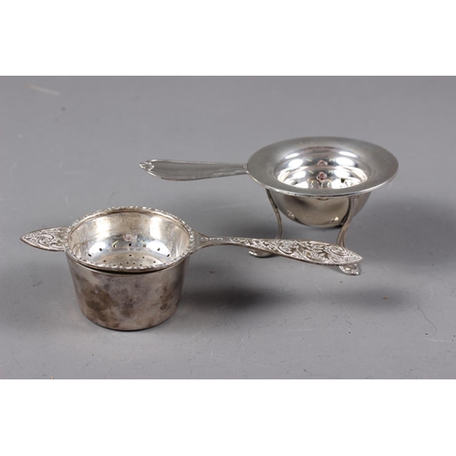 338 - A Danish silver tea strainer, on stand, and an English silver tea strainer with cast scrolled and le... 