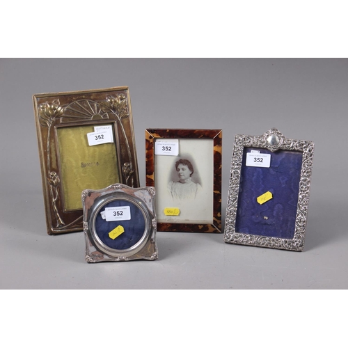 352 - A silver photo frame with scrolled and floral embossed decoration, a smaller similar, a tortoiseshel... 