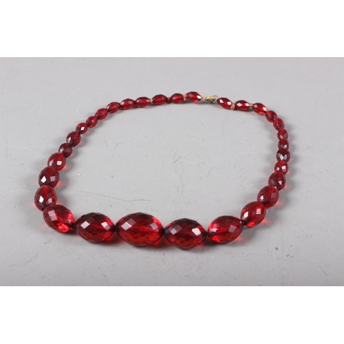 394 - A cherry amber? faceted graduated beaded necklace, 18 3/4