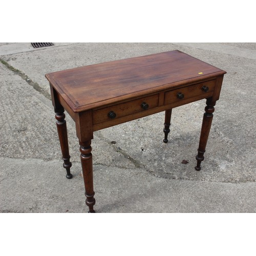 601 - A mahogany side table, fitted two drawers with brass handles, on turned supports, 35