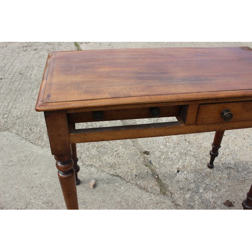 601 - A mahogany side table, fitted two drawers with brass handles, on turned supports, 35