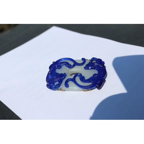 142 - A Chinese bi-colour carved brooch and a jade and silk necklace