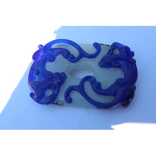 142 - A Chinese bi-colour carved brooch and a jade and silk necklace