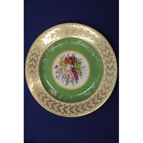 56 - Fourteen Sevres dessert plates with central floral decoration and green and gilt borders, 9 1/4