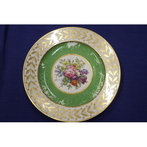 56 - Fourteen Sevres dessert plates with central floral decoration and green and gilt borders, 9 1/4