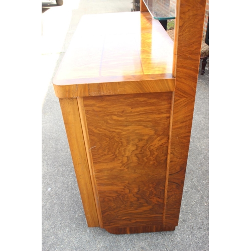 598 - A 1950s figured walnut sideboard with glazed doors over shelves, three drawers and cupboards enclose... 