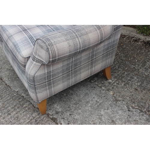 621 - A contemporary wing armchair, upholstered in a grey tartan fabric, on square taper supports