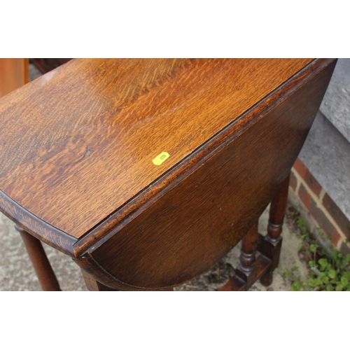 644 - An oak oval drop leaf occasional table, on turned and stretchered supports, 24