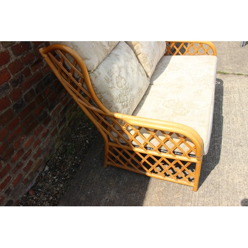 633 - A rattan loggia settee with loose seat and back cushions, and a brass and white painted bedhead, 37