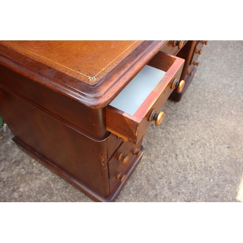 512 - A late 19th century mahogany double pedestal desk with tool lined top, nine drawers with knob handle... 