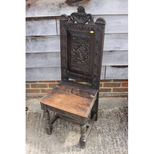 545 - A carved oak hall chair of 17th century design with martlet crest panel back, 45