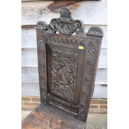 545 - A carved oak hall chair of 17th century design with martlet crest panel back, 45