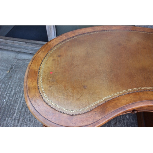 556 - A late 19th century figured walnut kidney-shaped double pedestal desk with tooled leather lined top,... 