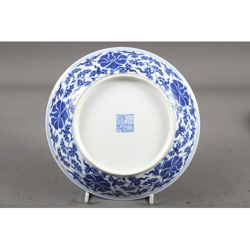 56 - A Chinese blue and white dish with floral and scrolled decoration with seal mark to base, 7 1/2