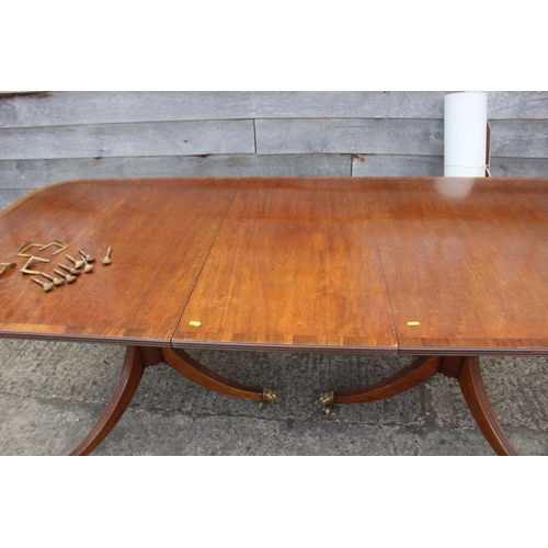 601 - A mahogany double pedestal dining table of Georgian design with one extra leaf, on turned columns an... 